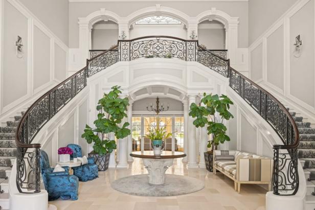 Eine elegante Eingangshalle mit einer geschwungenen Treppe und dekorativen Elementen.