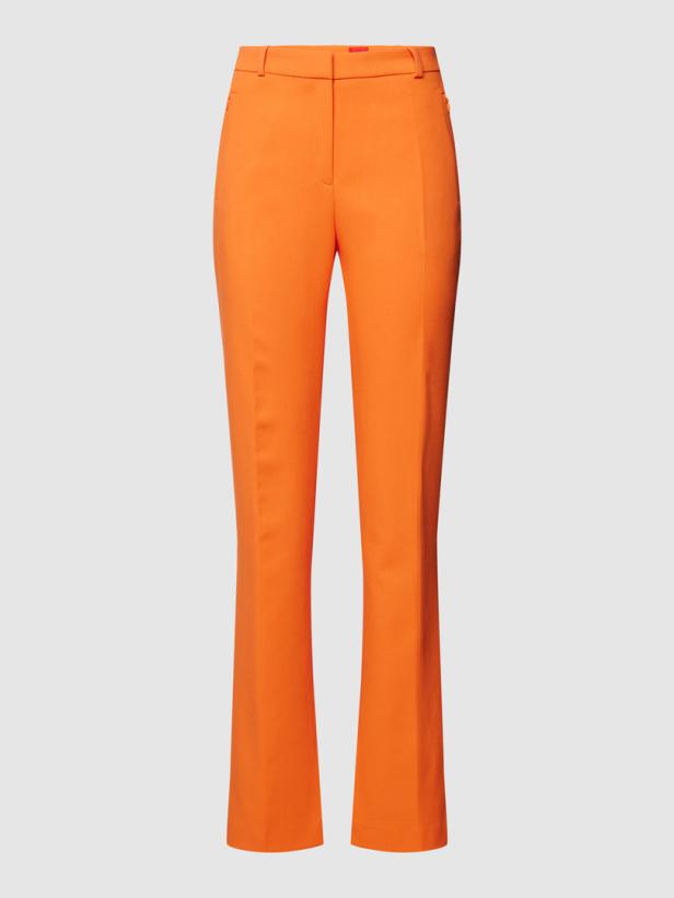 Eine orangefarbene Stoffhose vor einem neutralen Hintergrund.