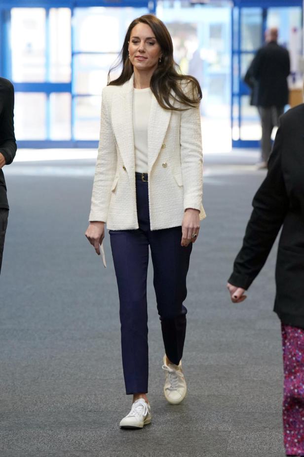 Kate Middleton trägt einen Blazer, eine Hose und Turnschuhe.