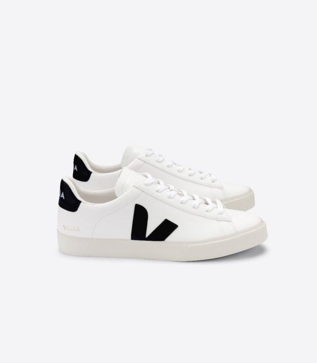 Zwei weiße Veja-Sneakers mit schwarzen Logos stehen vor einem weißen Hintergrund.
