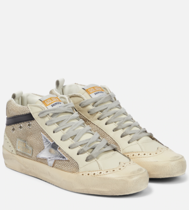 Ein Paar goldfarbene Golden Goose Mid Star Sneaker mit silbernem Stern.