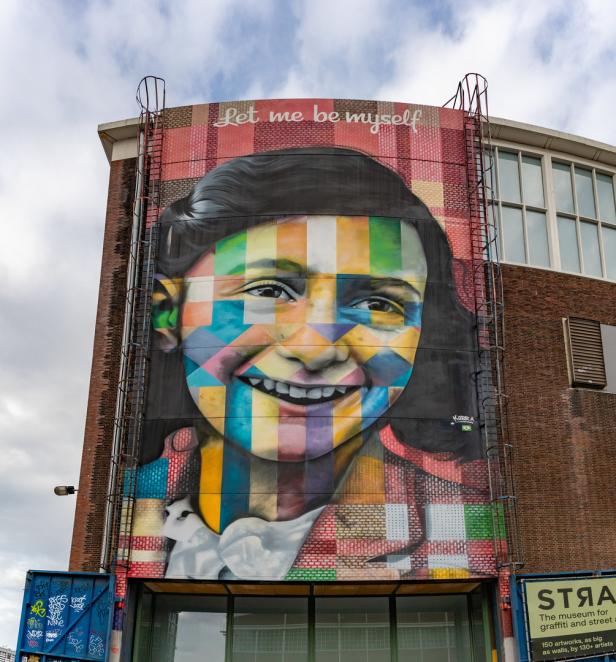 Ein farbenfrohes Wandgemälde von Anne Frank mit dem Schriftzug „Let me be myself“.