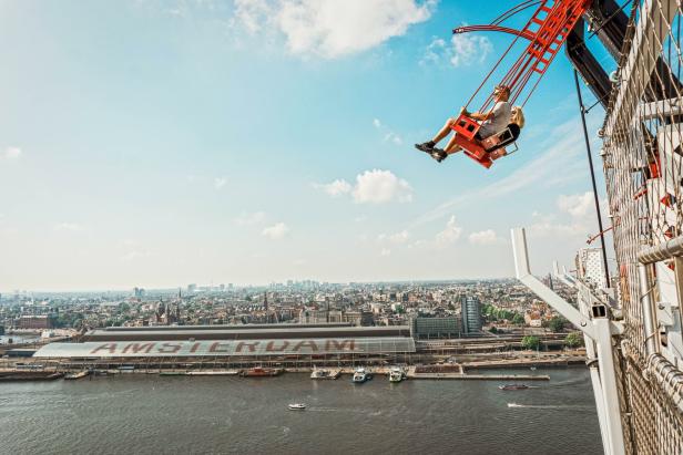 Ein Paar schwingt auf einer Riesenschaukel mit Blick auf Amsterdam.