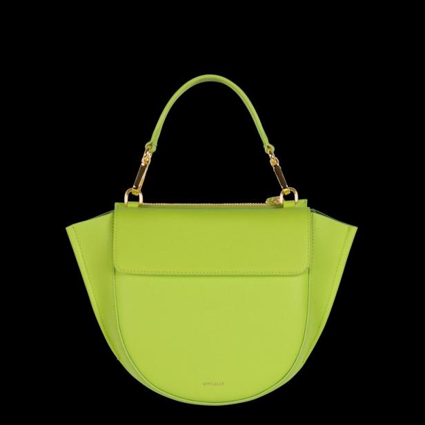 Eine hellgrüne Handtasche der Marke Wandler vor einem schwarzen Hintergrund.