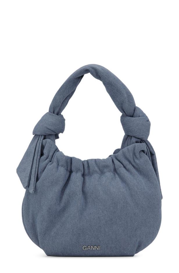 Eine blaue Handtasche der Marke Ganni mit gerafftem Stoff und Knoten am Henkel.