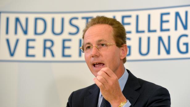 Georg Kapsch Ein Mann mit Brille gestikuliert vor dem Schriftzug „Industriellenvereinigung“.