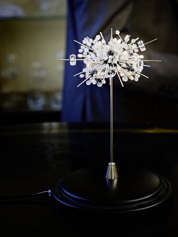 Eine dekorative Lampe mit Kristallverzierungen steht auf einem Tisch.