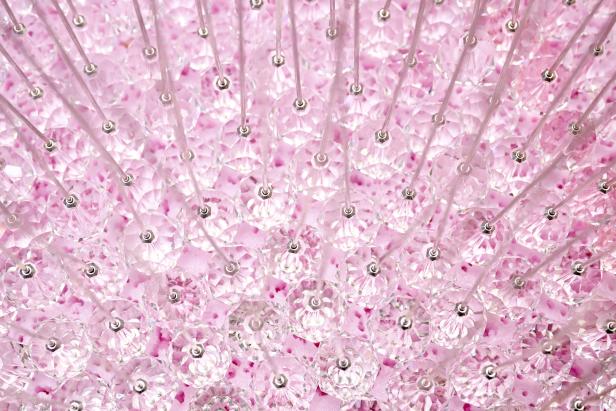 Nahaufnahme eines pinkfarbenen Kronleuchters mit vielen Kristallen.