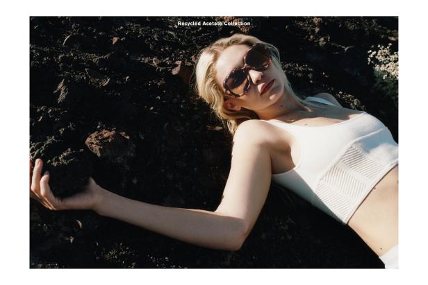 Eine blonde Frau mit Sonnenbrille liegt auf dunklem Lavagestein.