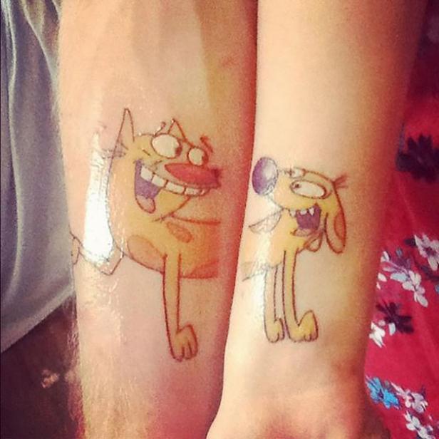 Auf zwei Unterarmen sind Tätowierungen von Katze und Hund aus der Zeichentrickserie „CatDog“ zu sehen.