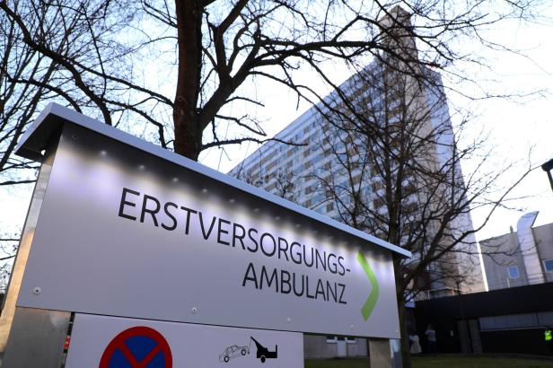 Ein Schild weist zur Erstversorgungs-Ambulanz, im Hintergrund ein hohes Gebäude.