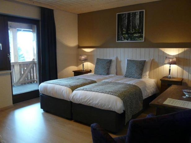 Ein Hotelzimmer mit zwei Betten und einem Balkon.