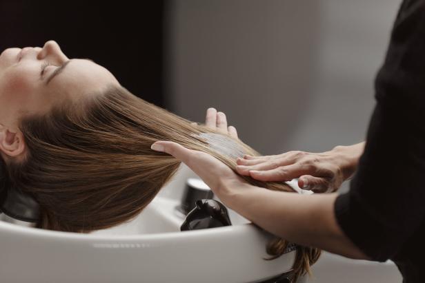Eine Frau bekommt im Friseursalon eine Haarkur.