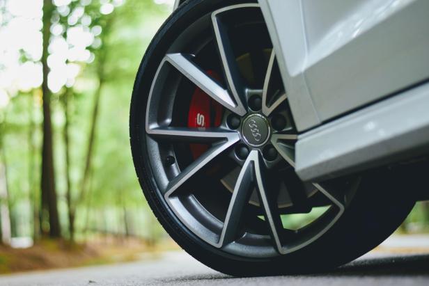 Nahaufnahme des Rads eines weißen Audi mit roten Bremssätteln.