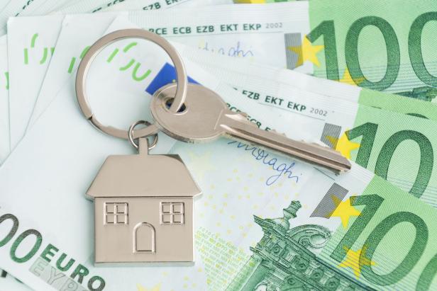Home keys and a small house on currencies euro background. The concept of renting or selling house or flat, mortgage, investment or real estate, property buying. Money for the housing plan