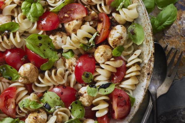 Caprese-Nudelsalat mit Tomaten, Mozzarella und Basilikum.