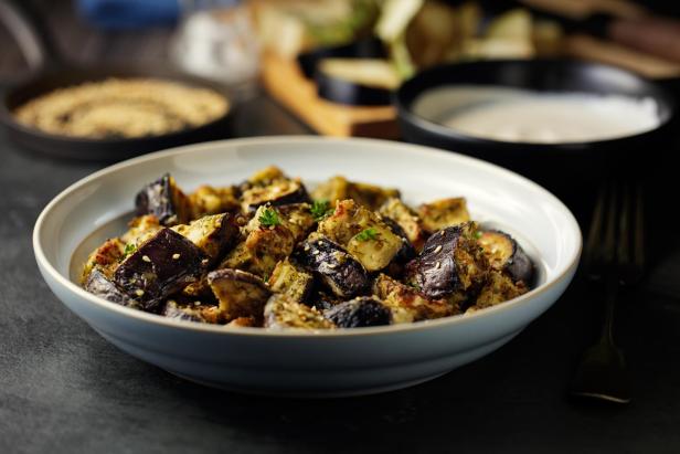 Gebratene Auberginenwürfel mit Sesam in einer Schüssel.
