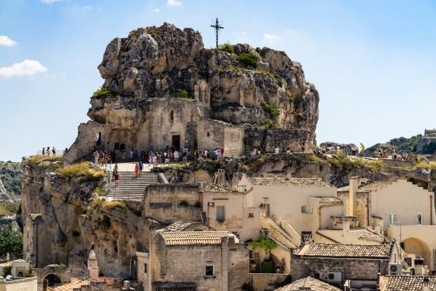 Blick auf die Felsenkirche Santa Maria de Idris in Matera, Italien, mit Besuchern.