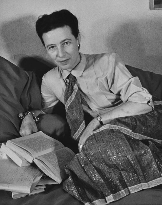 Porträt der französischen Schriftstellerin und Philosophin Simone de Beauvoir (1908 - 1986), wie sie auf einer Couch liegt, Paris, Frankreich, 1952.