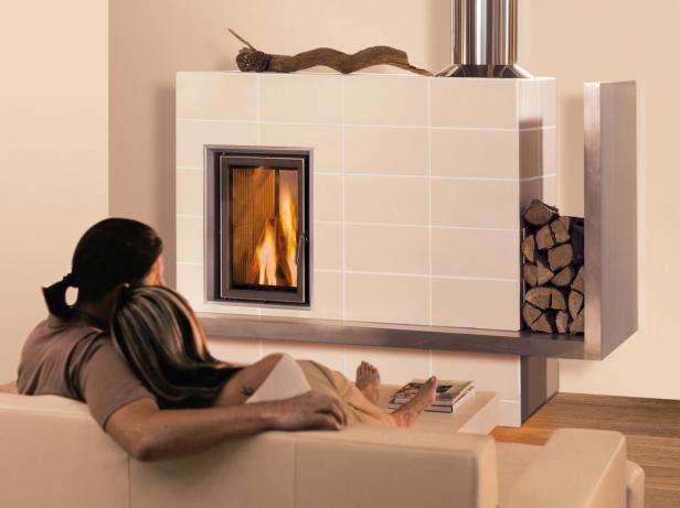 Ein Paar entspannt sich vor einem Kamin mit brennendem Feuer.