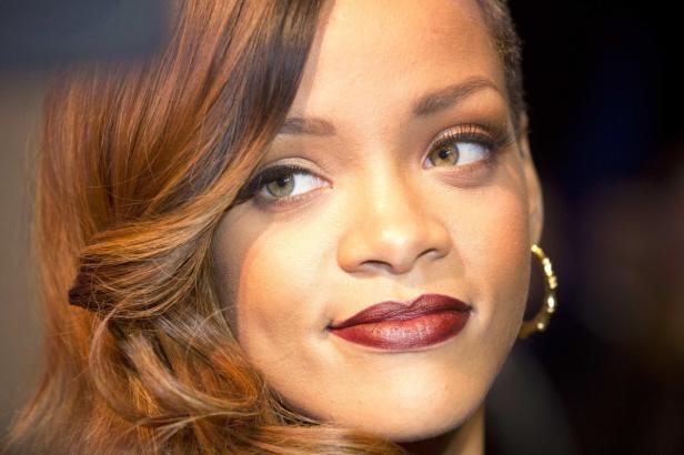 Nahaufnahme von Rihanna mit gewelltem Haar und dunklem Lippenstift.