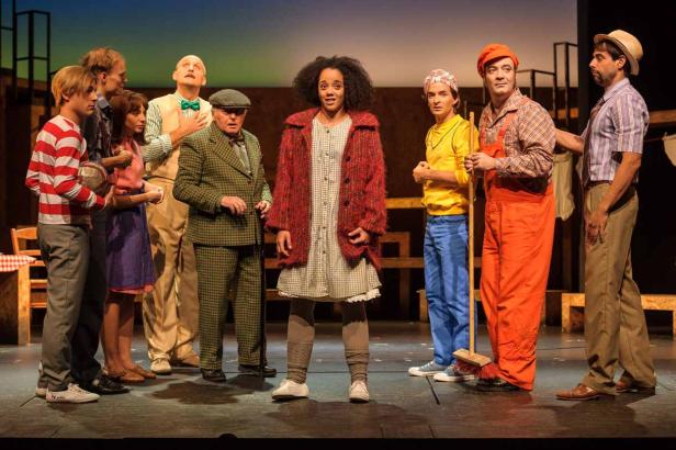 Eine Gruppe von Schauspielern steht auf einer Bühne in Kostümen.