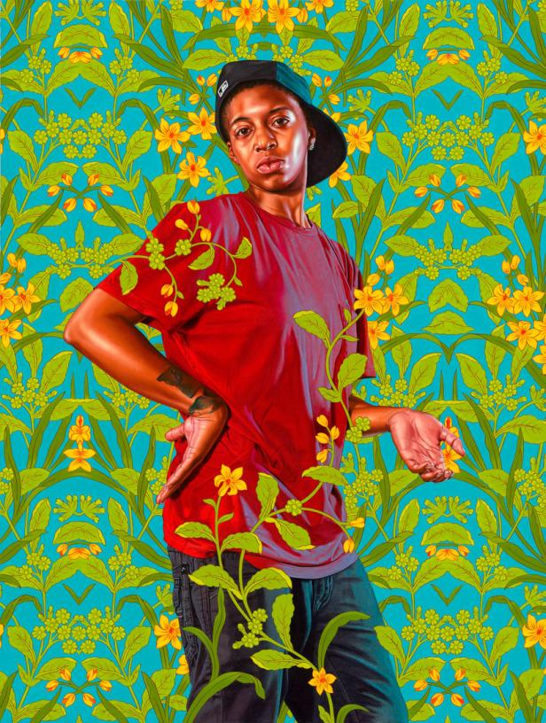 Eine Person mit rotem T-Shirt und Baseballkappe posiert vor einem floralen Hintergrund.