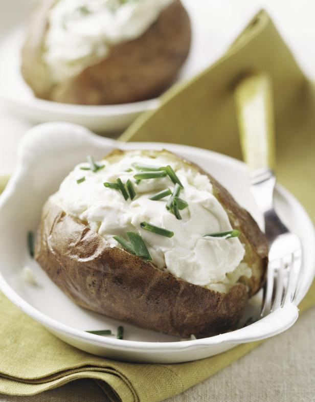 Ofenkartoffel mit Sauerrahm und Schnittlauch - Stock-Fotografie.