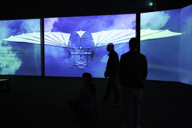 Besucher betrachten eine Ausstellung von Leonardo da Vincis Flugmaschine.
