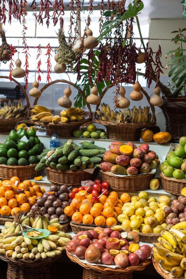 Eine große Auswahl an tropischen Früchten und Gemüse auf einem Markt präsentiert.