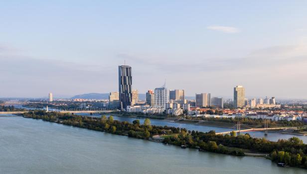 Luftaufnahme von Wien, Österreich, mit der Donau und der Skyline im Hintergrund.