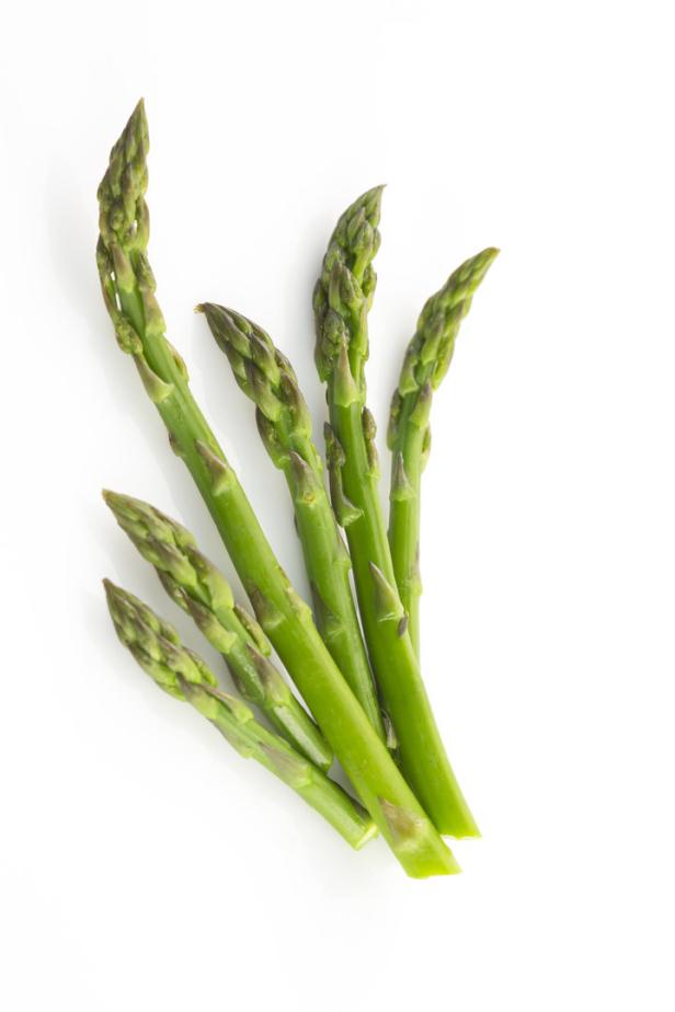 Mehrere Stangen grüner Spargel liegen auf einem weißen Hintergrund.