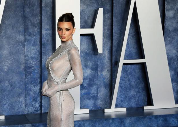 Emily Ratajkowski posiert in einem silbernen Kleid auf dem roten Teppich.