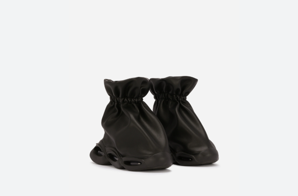 Zwei schwarze Stiefel mit gerafftem Schaft stehen vor einem weißen Hintergrund.