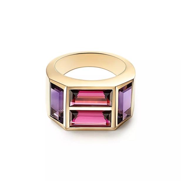Ein goldener Ring mit rechteckigen, violetten und pinkfarbenen Edelsteinen.