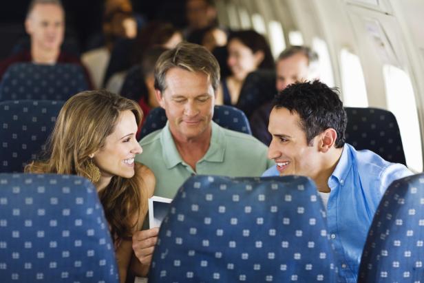 Ein Mann und eine Frau unterhalten sich in einem Flugzeug.