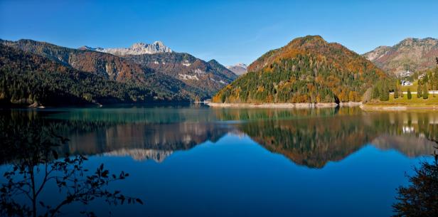 Der smaragdgrüne Lago di Cadore spiegelt die umliegenden Berge und Wälder wider.