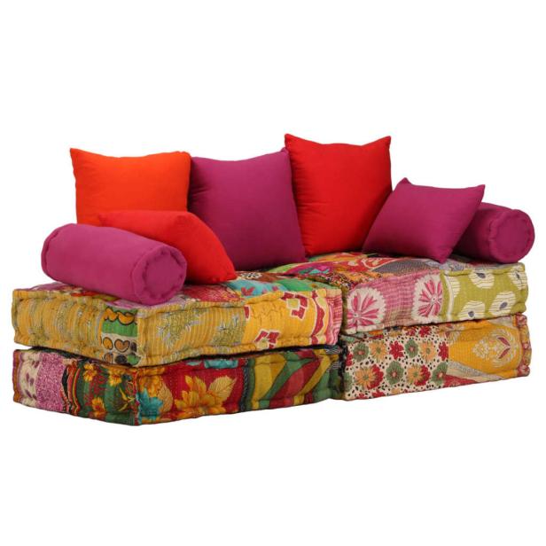 Ein buntes, zusammengesetztes Sofa mit Kissen in Rot-, Orange- und Lilatönen.