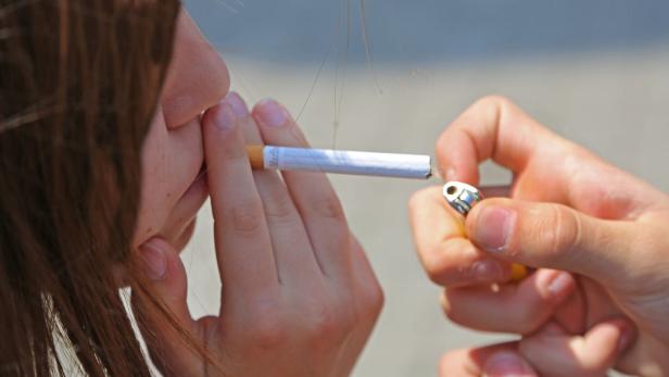 Eine Person zündet eine Zigarette der Marke Marlboro an.