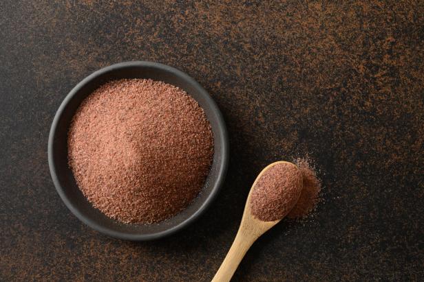 Eine Schale und ein Löffel mit indischem Schwarzsalz (Kala Namak).