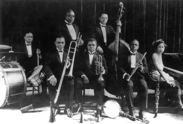 Eine Jazzband mit sieben Mitgliedern posiert mit ihren Instrumenten.