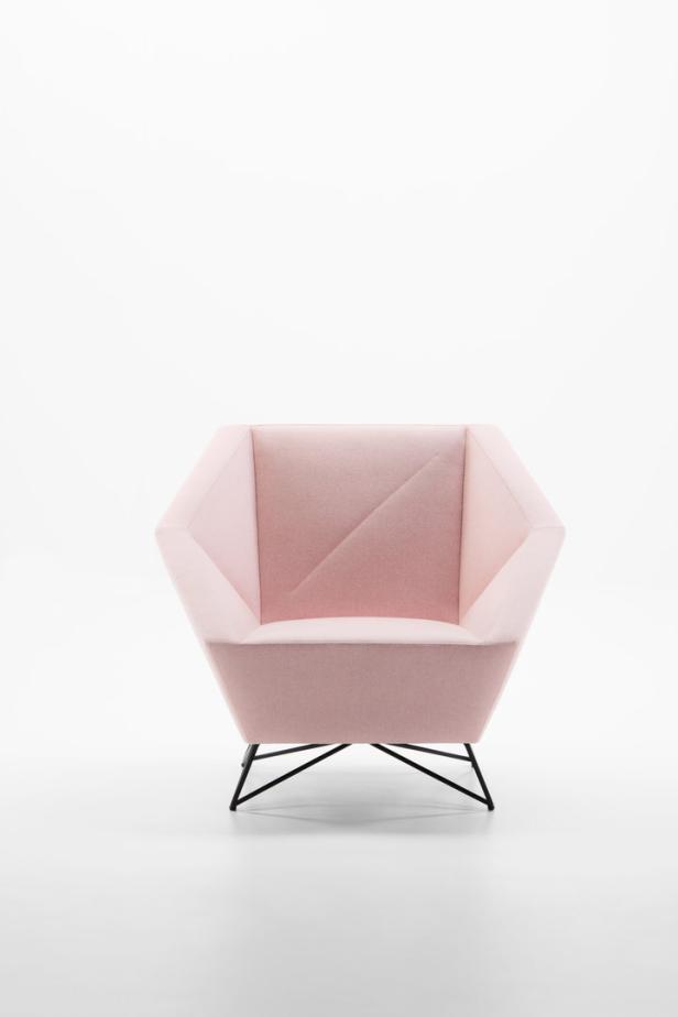 Ein rosafarbener Sessel mit geometrischem Design und schwarzem Metallgestell vor einem weißen Hintergrund.