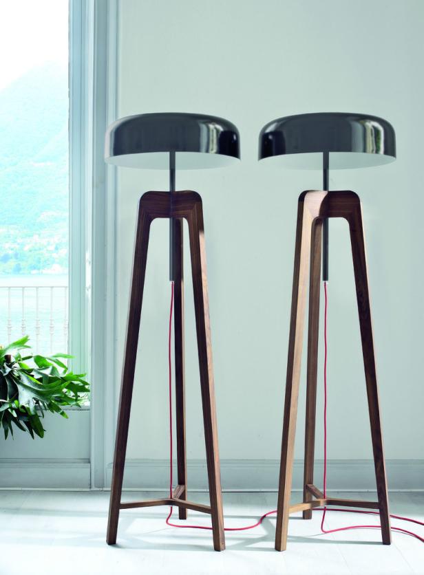 Zwei Stehlampen mit Holzgestell und schwarzem Lampenschirm stehen in einem Raum.