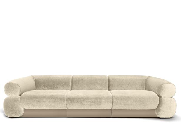 Ein beiges, modernes Sofa mit drei Sitzen vor einem weißen Hintergrund.