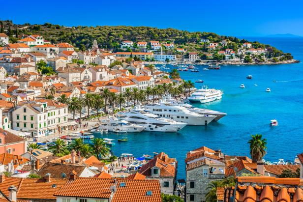 Blick auf die Küstenstadt Hvar in Kroatien mit Yachten im Hafen.