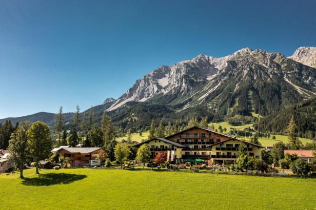 Das Almfrieden Hotel & Romantikchalet vor einer Bergkulisse.