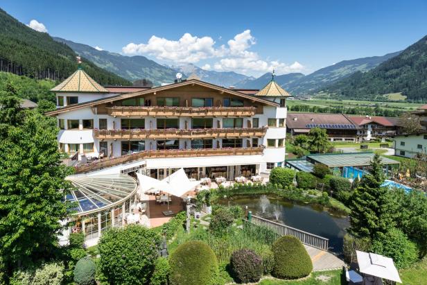 Das Hotel Magdalena**** liegt inmitten einer grünen Landschaft mit Bergen im Hintergrund.