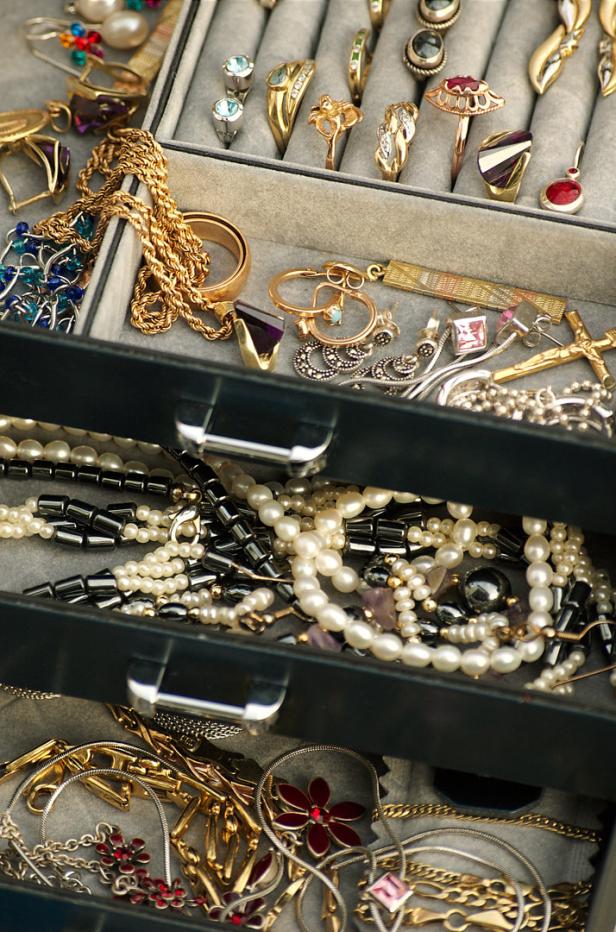 Eine geöffnete Schmuckschatulle mit verschiedenen Ringen, Ketten und Ohrringen.