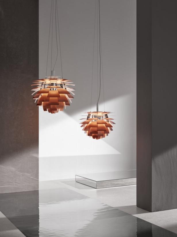 Zwei hängende, kupferfarbene Artischockenlampen in einem modern gestalteten Raum.