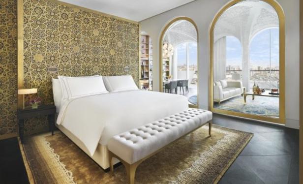 Ein luxuriöses Schlafzimmer mit orientalischem Dekor und Blick auf die Stadt.